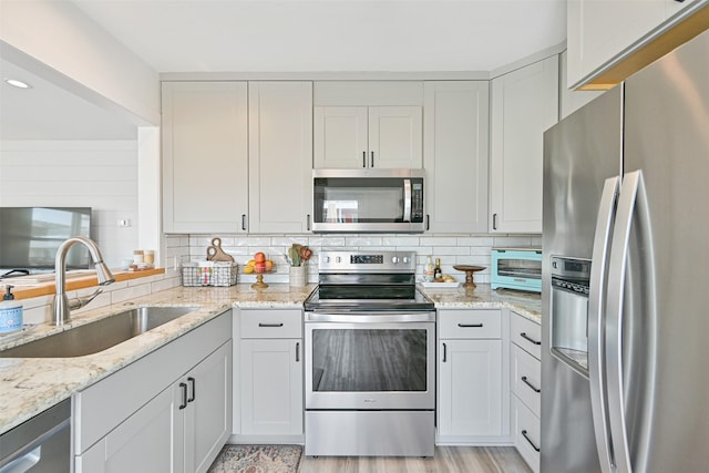 16716 Tahiti Way, Galveston, TX 77554 - kitchen with stainless steel appliances, a sink, backsplash, light stone counters, and recessed lighting