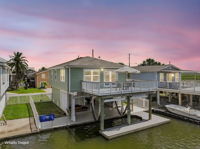 16716 Tahiti Way, Galveston, TX 77554 - rear view of house with boat lift, fence, a deck with water view, and an attached garage