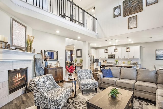 13814 Russell Ct, Mont Belvieu, TX 77523 - living room with a towering ceiling, wood finished floors, a fireplace, and recessed lighting