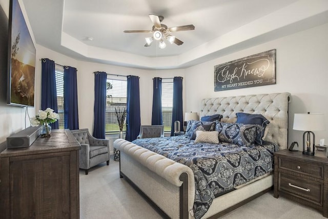 13814 Russell Ct, Mont Belvieu, TX 77523 - bedroom with light colored carpet, a tray ceiling, and ceiling fan