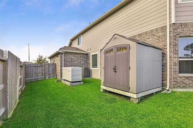 13814 Russell Ct, Mont Belvieu, TX 77523 - back of property featuring brick siding, a storage unit, an outdoor structure, and central air condition unit