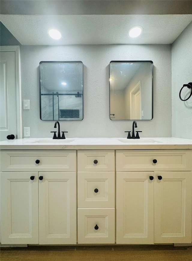 full bath with double vanity, a shower, and recessed lighting
