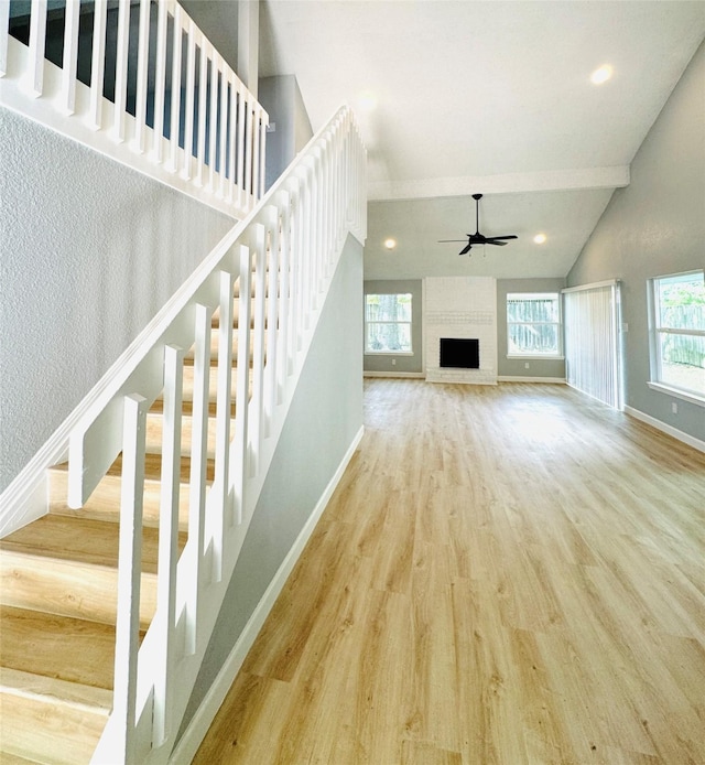 unfurnished living room featuring stairs, a ceiling fan, wood finished floors, baseboards, and recessed lighting