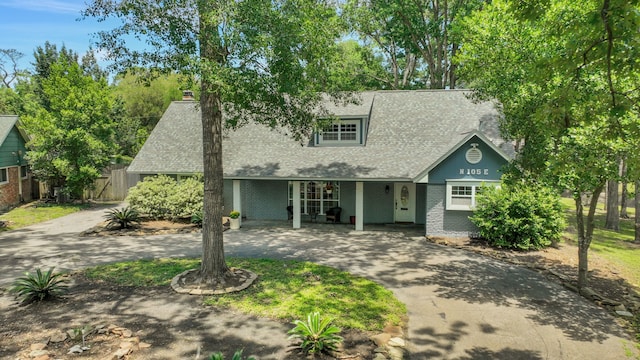 105 N Delmont Dr E, Conroe, TX 77301 - view of front facade featuring curved driveway, brick siding, a chimney, a shingled roof, and fence