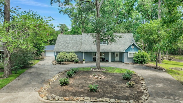 105 N Delmont Dr E, Conroe, TX 77301 - view of front of home with curved driveway, roof with shingles, and covered porch