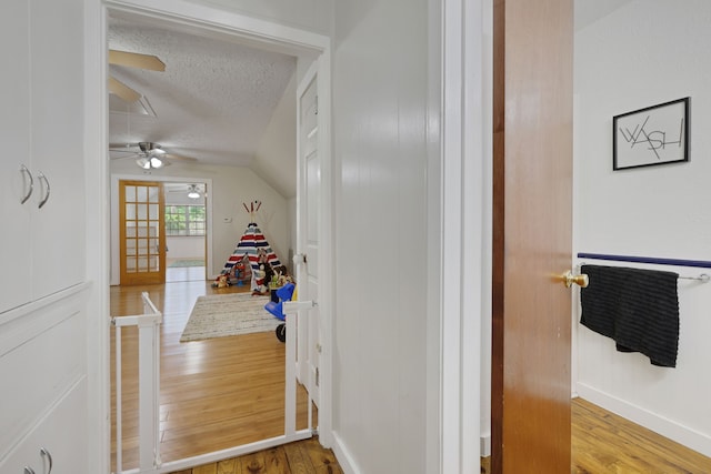 105 N Delmont Dr E, Conroe, TX 77301 - hallway with wood finished floors, a textured ceiling, vaulted ceiling, and baseboards