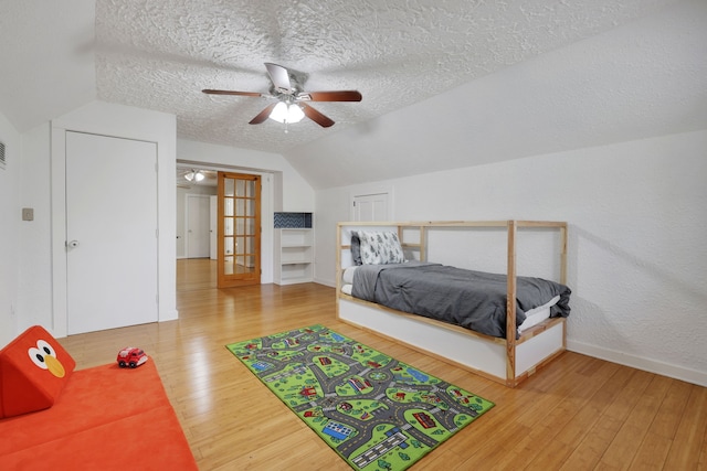 105 N Delmont Dr E, Conroe, TX 77301 - bedroom featuring hardwood / wood-style floors, a textured ceiling, lofted ceiling, baseboards, and ceiling fan