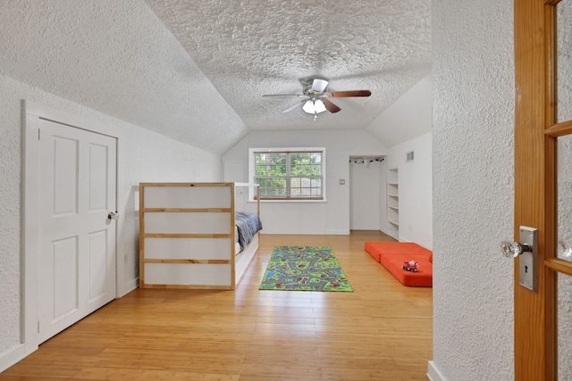 105 N Delmont Dr E, Conroe, TX 77301 - additional living space with a textured ceiling, wood finished floors, ceiling fan, lofted ceiling, and a textured wall