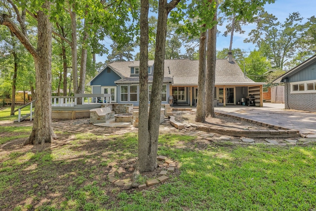105 N Delmont Dr E, Conroe, TX 77301 - back of property with a patio, a fire pit, and a shingled roof