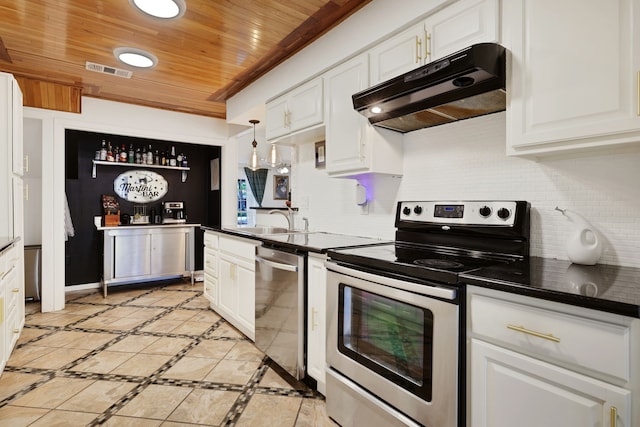 105 N Delmont Dr E, Conroe, TX 77301 - kitchen with stainless steel appliances, under cabinet range hood, wood ceiling, dark countertops, and white cabinetry