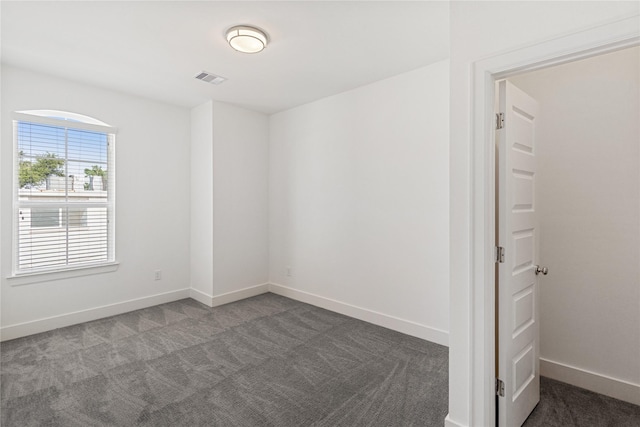 carpeted spare room featuring baseboards