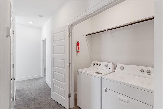 washroom featuring washing machine and clothes dryer, carpet, and baseboards