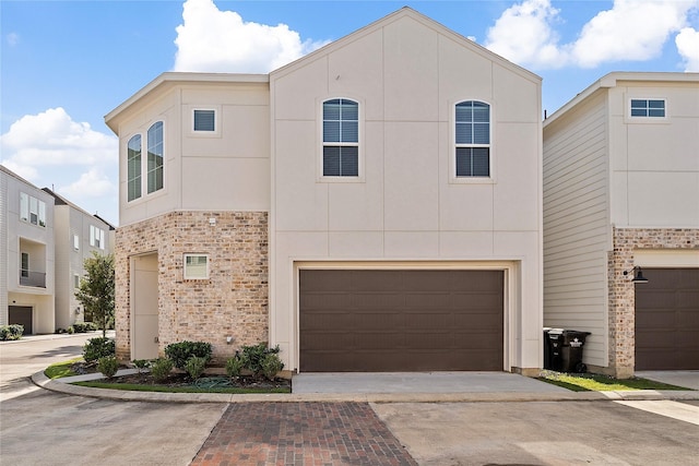 view of property featuring an attached garage, concrete driveway, and stucco siding