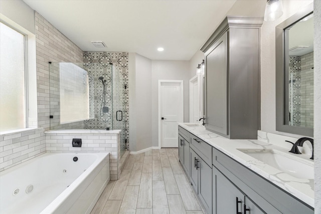 15127 Woodford Hollow Ln, Cypress, TX 77429 - full bath featuring double vanity, a tub with jets, a shower stall, wood finished floors, and baseboards