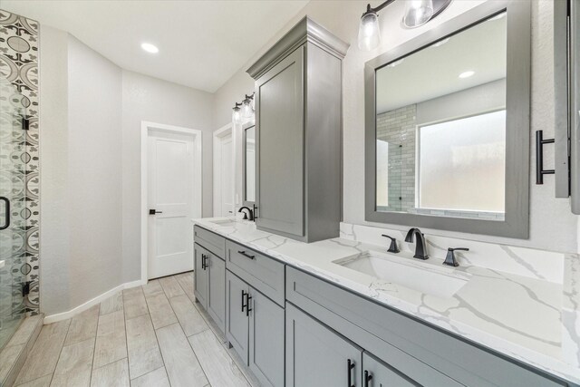 15127 Woodford Hollow Ln, Cypress, TX 77429 - full bath with a shower with shower door, double vanity, recessed lighting, baseboards, and wood finished floors