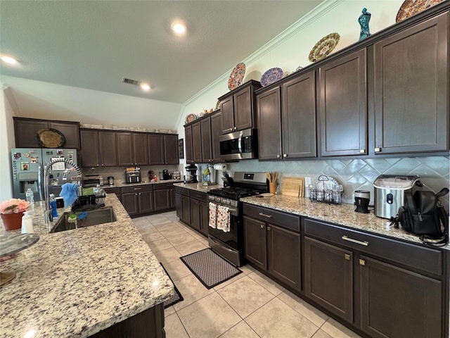 13510 Dovetail Canyon Ct, Rosharon, TX 77583 - kitchen with appliances with stainless steel finishes, light tile patterned flooring, ornamental molding, dark brown cabinets, and decorative backsplash