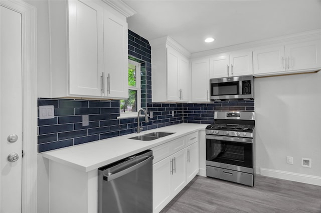 110 Prune St, La Marque, TX 77568 - kitchen with appliances with stainless steel finishes, a sink, light countertops, tasteful backsplash, and white cabinets