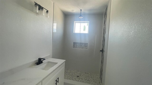 9316 Waller St, Houston, TX 77012 - bathroom featuring a stall shower, a textured wall, and vanity