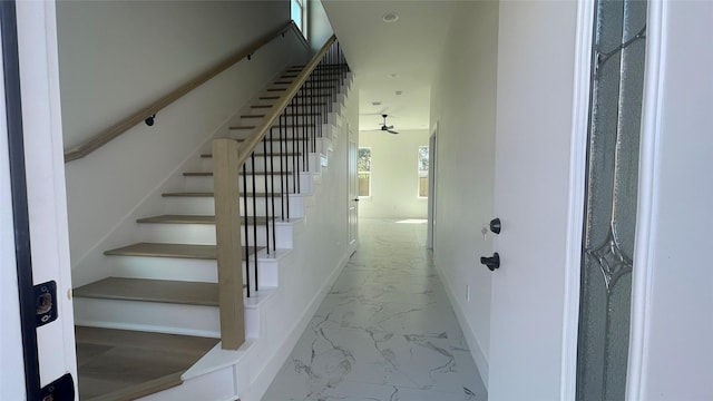 9316 Waller St, Houston, TX 77012 - staircase featuring marble finish floors, a ceiling fan, and baseboards