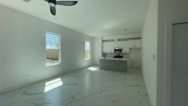 9316 Waller St, Houston, TX 77012 - unfurnished living room with light marble finish flooring, baseboards, ceiling fan, and a sink