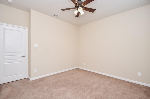 empty room featuring light colored carpet, ceiling fan, and baseboards