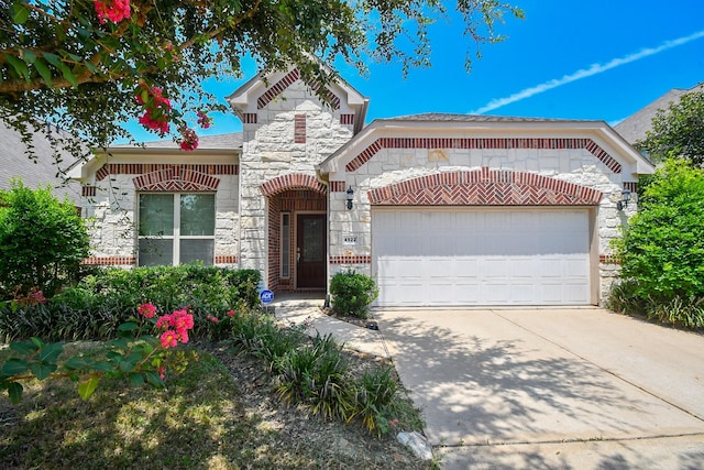 view of front of property with stone siding, driveway, and an attached garage