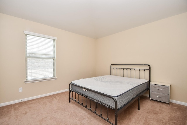 bedroom featuring light carpet and baseboards