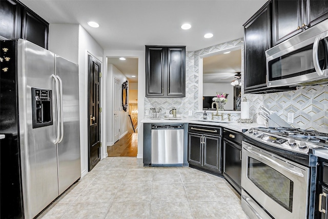 13600 Breton Ridge St Unit 25B, Houston, TX 77070 - kitchen featuring appliances with stainless steel finishes, dark cabinetry, a sink, backsplash, and recessed lighting