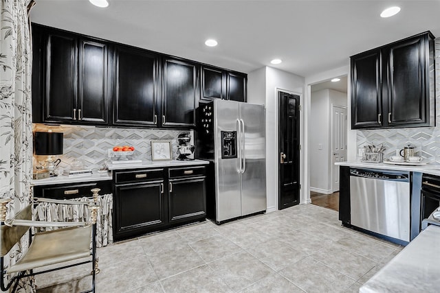 13600 Breton Ridge St Unit 25B, Houston, TX 77070 - kitchen featuring dark cabinetry, appliances with stainless steel finishes, light countertops, tasteful backsplash, and recessed lighting