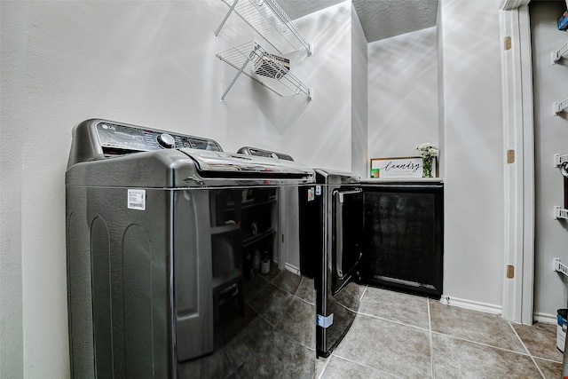 13600 Breton Ridge St Unit 25B, Houston, TX 77070 - washroom with washer and clothes dryer, tile patterned floors, and baseboards