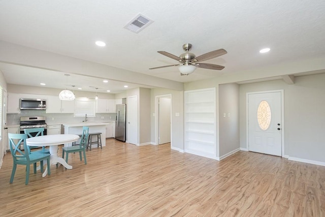 foyer entrance with light wood-style floors, a ceiling fan, baseboards, and recessed lighting