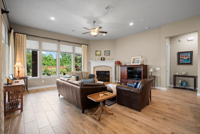 living room with baseboards, a ceiling fan, recessed lighting, light wood-type flooring, and a glass covered fireplace