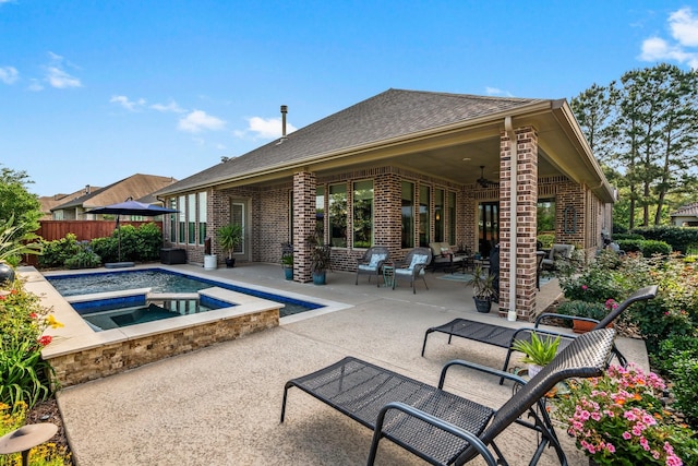 view of pool featuring an in-ground hot tub, a patio, fence, and a ceiling fan