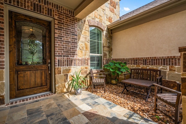entrance to property featuring stone siding and brick siding