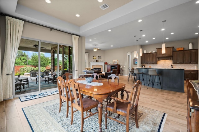 dining space featuring ceiling fan, a glass covered fireplace, and recessed lighting