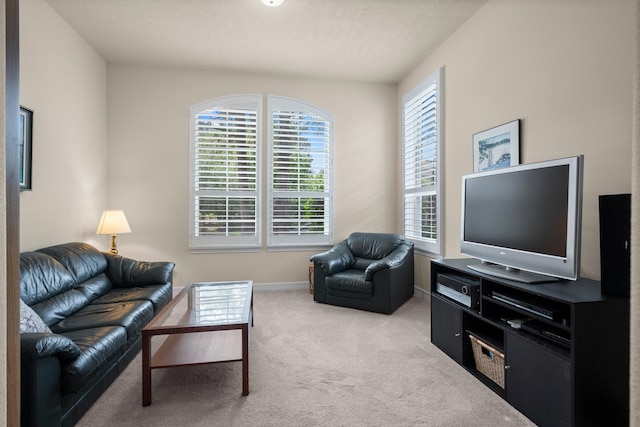 carpeted living area with baseboards