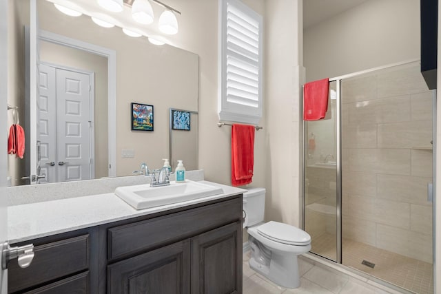 full bathroom featuring a stall shower, toilet, vanity, and tile patterned floors
