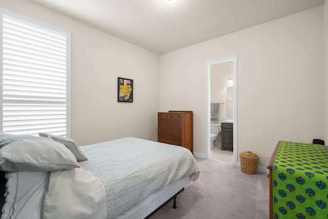 bedroom with carpet flooring, baseboards, and ensuite bathroom