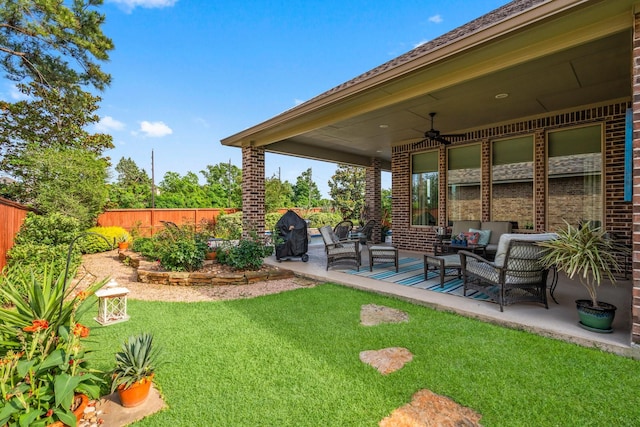 view of yard with a ceiling fan, an outdoor living space, and a patio