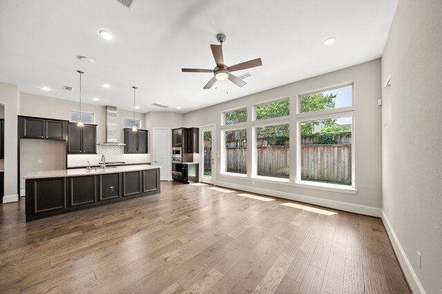1404 Arkley Way, Houston, TX 77055 - kitchen featuring wall chimney exhaust hood, light countertops, decorative backsplash, a ceiling fan, and baseboards
