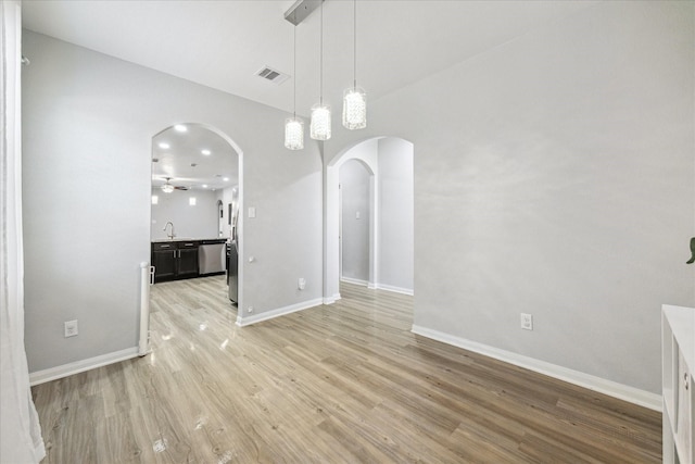 21022 Solstice Point Dr, Hockley, TX 77447 - unfurnished dining area featuring arched walkways, light wood-style floors, and baseboards