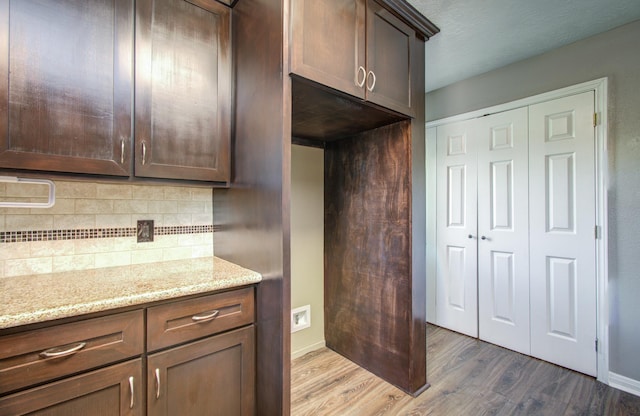619 Shadylawn St, Shoreacres, TX 77571 - kitchen with wood finished floors, tasteful backsplash, light stone counters, baseboards, and dark brown cabinetry