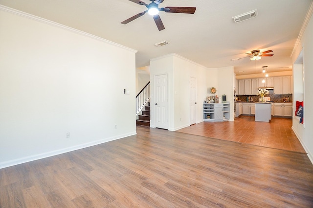 18106 Rileybrook Cir, Houston, TX 77094 - unfurnished living room featuring a ceiling fan, crown molding, wood finished floors, stairs, and baseboards