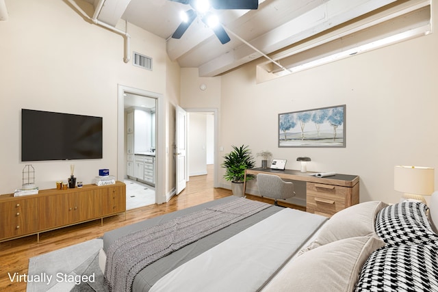 1120 Texas St Unit 7D, Houston, TX 77002 - bedroom featuring light wood finished floors, a towering ceiling, beam ceiling, connected bathroom, and a ceiling fan