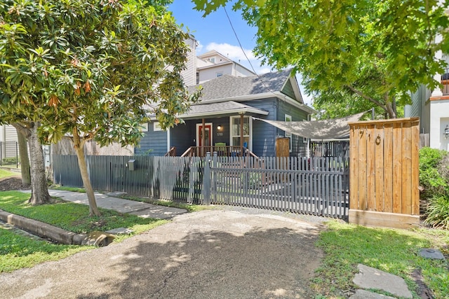 1710 Spring St, Houston, TX 77007 - view of front of house featuring a fenced front yard, a porch, driveway, a gate, and a shingled roof