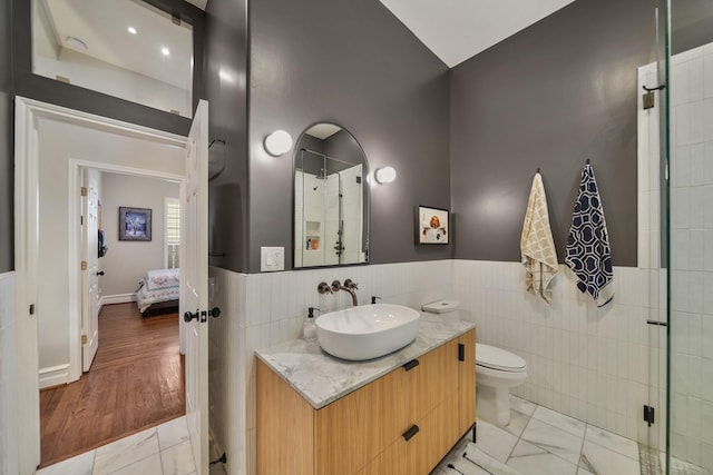 1710 Spring St, Houston, TX 77007 - bathroom featuring tile walls, toilet, vanity, wainscoting, and connected bathroom