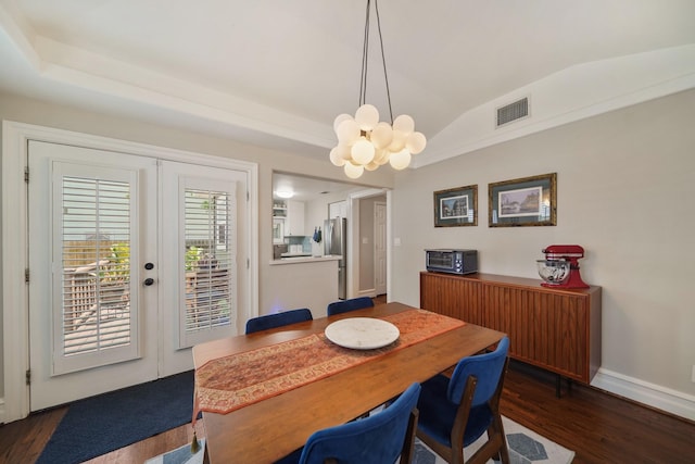 dining space with a chandelier, dark wood-style flooring, lofted ceiling, and baseboards