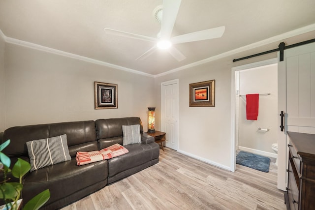 1710 Spring St, Houston, TX 77007 - living room featuring a ceiling fan, a barn door, light wood-type flooring, ornamental molding, and baseboards