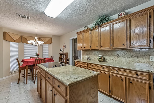 2507 18th St N, Texas City, TX 77590 - kitchen featuring black electric stovetop, a chandelier, a kitchen island, hanging light fixtures, and a textured ceiling