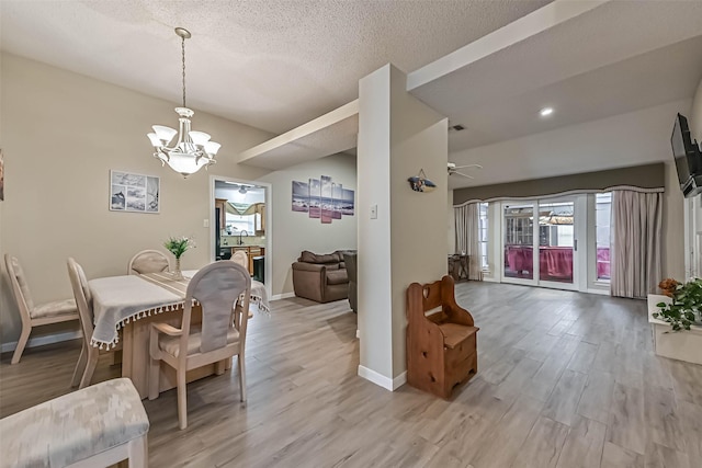 2507 18th St N, Texas City, TX 77590 - dining area with a chandelier, light wood-type flooring, ceiling fan, baseboards, and a textured ceiling